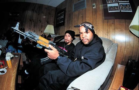 Rapper Ice Cube holding a rifle.