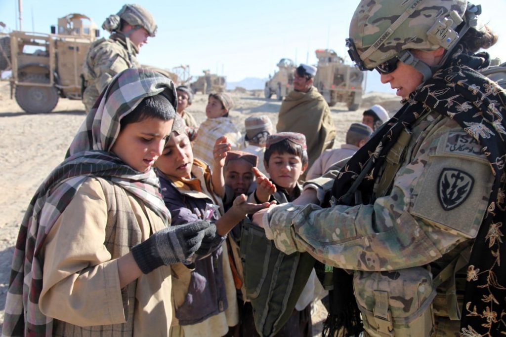 Femme soldat interagissant avec les enfants.