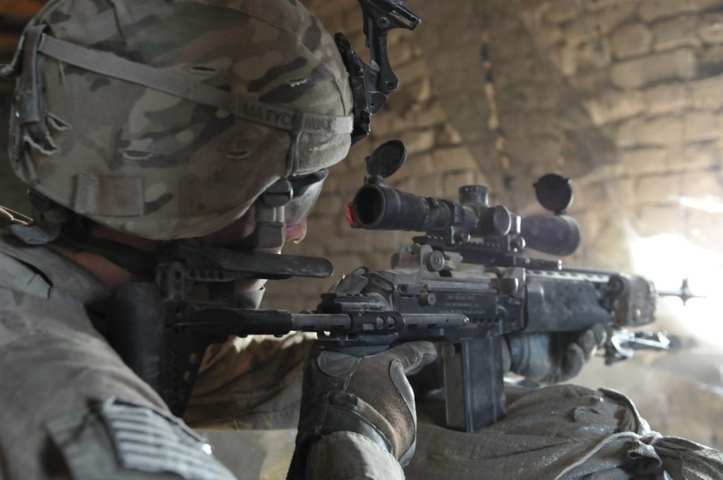 US Soldier firing M14 EMR through hole in wall.